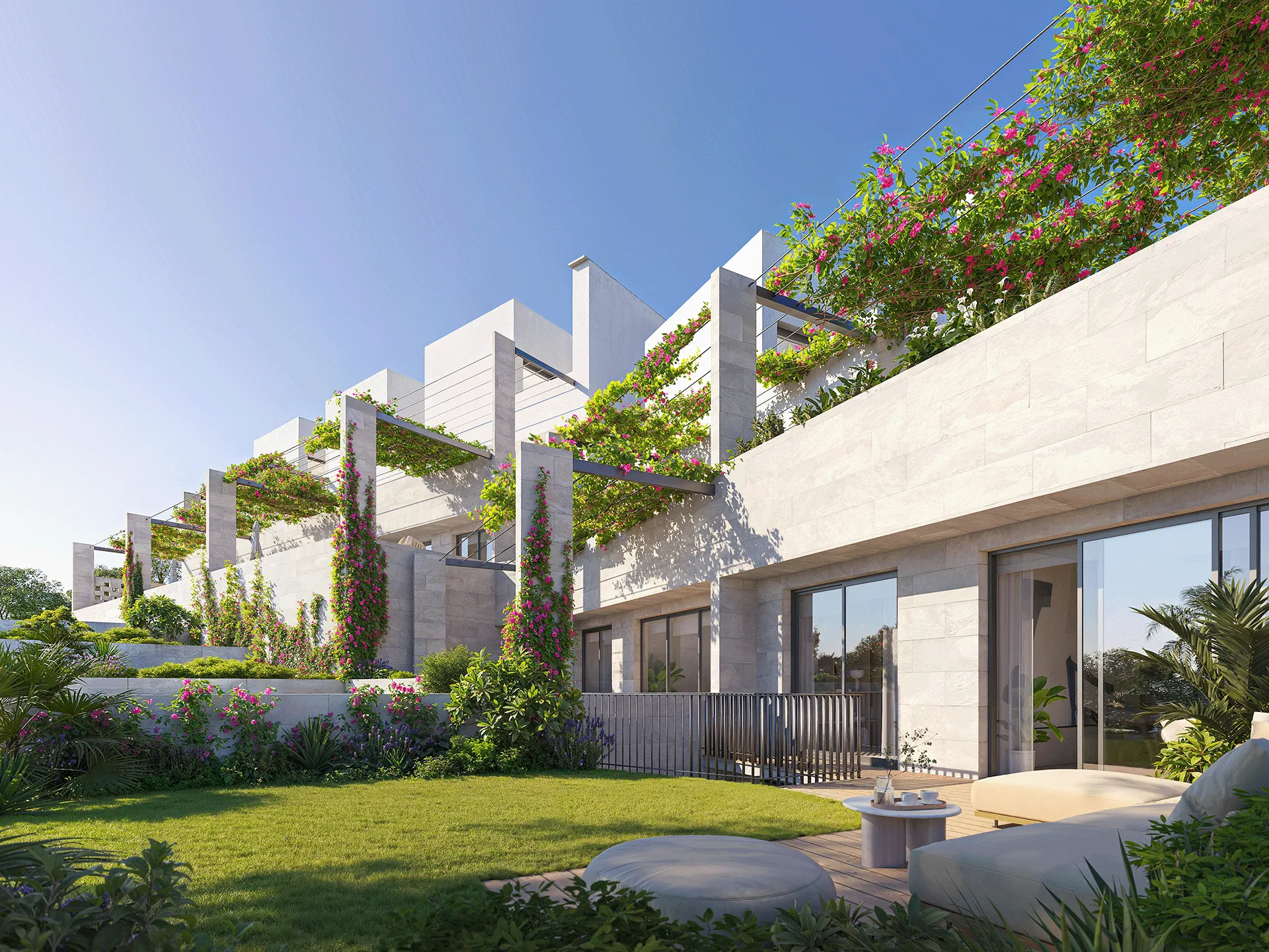 Apartamentos modernos com terraço, plantas verdes, trepadeiras floridas e assentos externos em um dia de sol.